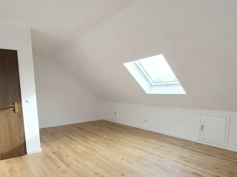 Fertiges Dachzimmer mit Dachfenster und Holzboden